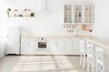 Interior of modern sunny kitchen in Scandinavian style apartment. Light kitchen furniture with utensils