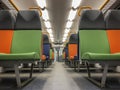 Interior of a modern train, perspective of an empty carriage with bright multi-colored seats Royalty Free Stock Photo