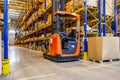 Interior of a modern warehouse storage with rows and goods boxes on high shelves. Pallet truck parking near shelves