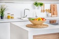 Interior of modern white kitchen with induction cooking heater an vegetables on the table