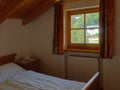 Interior of mountain wooden lodge bedroom with window