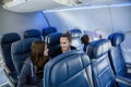 Interior of a nearly empty airplane. Photo of a family sitting near the back of the plane on a not full flight. Royalty Free Stock Photo