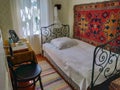 Interior of nice bedroom in vintage rural style. Room with comfortable canopy double bed and retro chair. Royalty Free Stock Photo