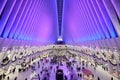 Interior of the Oculus in Manhattan, New York City with purple lights illuminating the giant hall