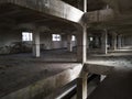 Interior of an old abandoned concrete hall. Empty messy industrial warehouse with several floors and a hole in the floor