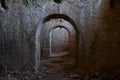 The interior of an old building with a long corridor with doorways with semicircular arches Royalty Free Stock Photo