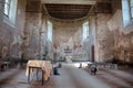 Interior of an old filial church with simple wooden cross and stone altar. Royalty Free Stock Photo