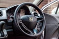 The interior of an old Japanese car Honda Stream with a view of the dashboard, steering wheel, speedometer and logo with letter H