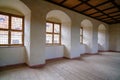 The interior of an old medieval castle, hall after reconstruction. Lots of large wide windows and wood plank flooring Royalty Free Stock Photo