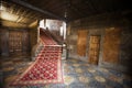 Interior of an old Spanish house with red carpet, stairs and doors