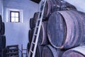 Interior of an old wine cellar with wooden barrels with a ladder leaning on them. Concept grape, drink, wine, alcohol, vineyards Royalty Free Stock Photo