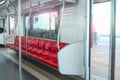 Interior of a passenger car of a commuter train. Red plastic seats and chrome handrails inside an electric train carriage car Royalty Free Stock Photo