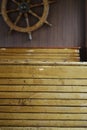 Interior of the passenger compartment on the boat, wooden seats and a steering wheel