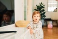 Portrait of funny toddler girl trying to open drawer Royalty Free Stock Photo