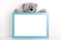 Interior poster mock up for nurcery, children`s room with vertical wooden frame and teddy bear on white wall background Royalty Free Stock Photo