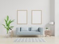Interior poster mockup with vertical empty wooden frame standing on wooden floor with sofa and cabinet