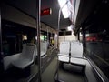 Interior of a public transport bus with empty gray seats and no passengers