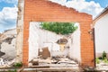 Interior remains of hurricane or earthquake disaster damage on ruined old house in the city with collapsed walls, roof and bricks