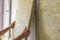 Worker insulating a room wall with mineral rock wool thermal insulation Royalty Free Stock Photo