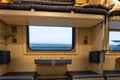 The interior of a reserved seat car of the Russian Railways. Window, top and bottom shelves, seats, table, sockets.