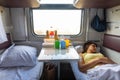 Interior of a reserved seat train car, a girl sleeps on the lower shelf Royalty Free Stock Photo