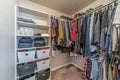 Interior of residential home walk in closet with built in open storage shelves
