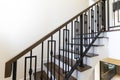 Interior of residential house or hotel. Contemporary wooden stairs with forged rails.