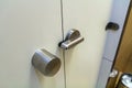 Interior of restroom toilet, white closed door with lock and stainless knob. Privacy and hygiene concept
