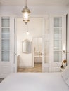 Interior of retro or classic style bedroom with vintage chandelier. View to bathroom decorated in beige color with bath Royalty Free Stock Photo