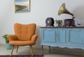 Retro orange armchair, vintage wooden light blue sideboard, old phonograph gramophone and vinyl records