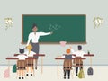 Female math teacher explaining multiplication to elementary school pupils