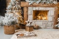 The interior of a room with a fireplace, Christmas trees with artificial snow and garlands, a blanket and a tray with