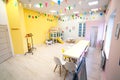 Interior room in kindergarten with yellow walls and colorful flags Royalty Free Stock Photo
