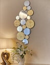 Interior room lamp vase with flowers and a decorative mirror on a light wall Royalty Free Stock Photo