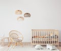 Interior of Scandinavian baby room with comfortable crib and rattan armchair in nursery decor