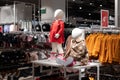 interior of a shop selling clothes for little girls, mannequins in the center of the hall