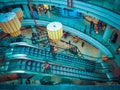 interior shopping mall structure of elevator with shopping women in teal color light