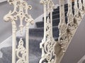 Interior shot of carpeted staircase with ornamental white cast iron balustrades