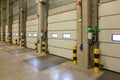 Interior shot of a warehouse with a row of doors and control panels next to it Royalty Free Stock Photo