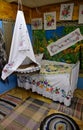 Interior of sleeping room with bed and old cradle decorated with embroideries in Russian style