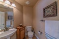 Interior of a small bathroom with pedestal sink and woven floor cabinet Royalty Free Stock Photo