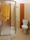 The interior of a small bathroom in soft and warm beige colors. Placement of shower and toilet in the budget toilet. Body hygiene
