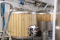 Interior of small brewery with tanks for beer fermentation and kegs