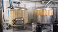 Interior of small brewery with tanks for beer fermentation and kegs