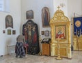 Woman prays in the Orthodox Church. The interior of a small provincial church, the interior decoration. Icons, prayers. Russia