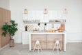 Interior of small white kitchen with fresh fruit, two glasses of orange juice, baguette, red caviar, croissant and Royalty Free Stock Photo