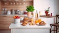 Interior of small white kitchen with fresh fruit, two glasses of orange juice, baguette, red caviar, croissant and cookies with