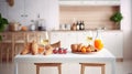 Interior of small white kitchen with fresh fruit, two glasses of orange juice, baguette, red caviar, croissant and cookies with