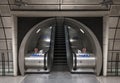 Interior of Southwark Underground Station, London showing escalators in tunnel.