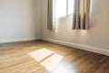 Interior space, empty room, laminate wooden floor with opened window receiving sunlight in the morning Royalty Free Stock Photo